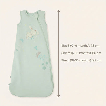 Zelkii® baby sleep sack size and fit chart showing total length measurements. Size S (0–6 months) measures 73 cm, Size M (6–18 months) measures 86 cm, and Size L (18–36 months) measures 99 cm, displayed alongside a cream sleep sack with bunnyillustration.