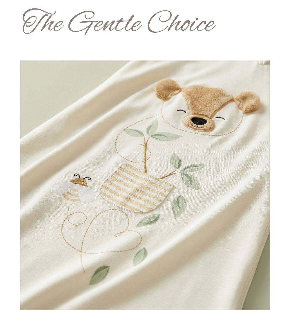 Close-up of a cream bamboo baby sleep sack with embroidered woodland illustration.