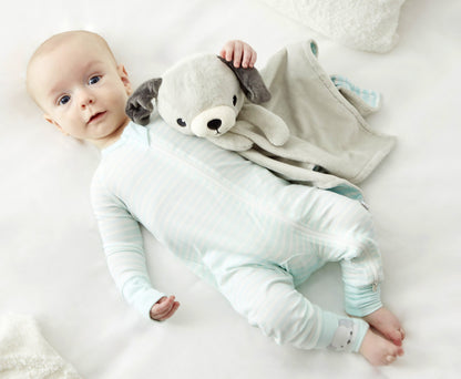 A baby in Zelkii's striped pyjamas (with a puppy on the cuff) lies next to the 'asleep' Zelkii puppy LuviDuvi lovey.