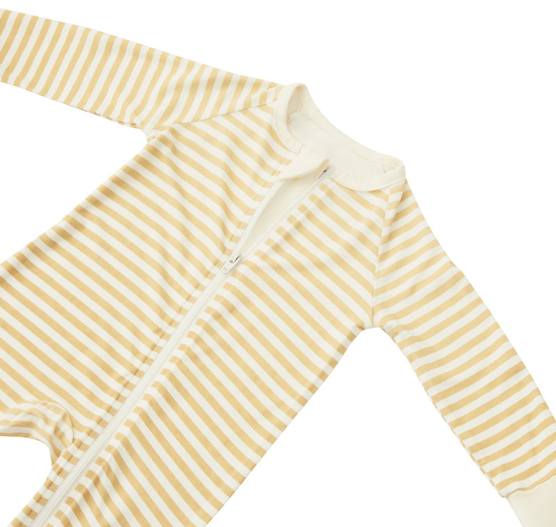 A flat lay of the Zelkii bamboo baby pyjama, showing the yellow and cream striped pattern and long sleeves.