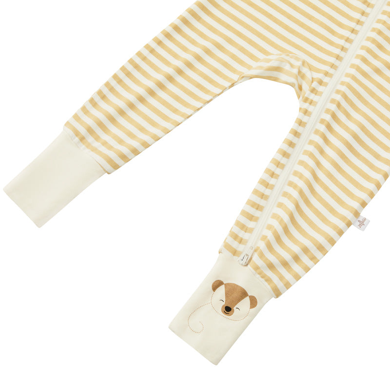Detail shot of the Zelkii bamboo pyjamas in a yellow and cream stripe, focusing on the teddy bear embroidered on the cuff.