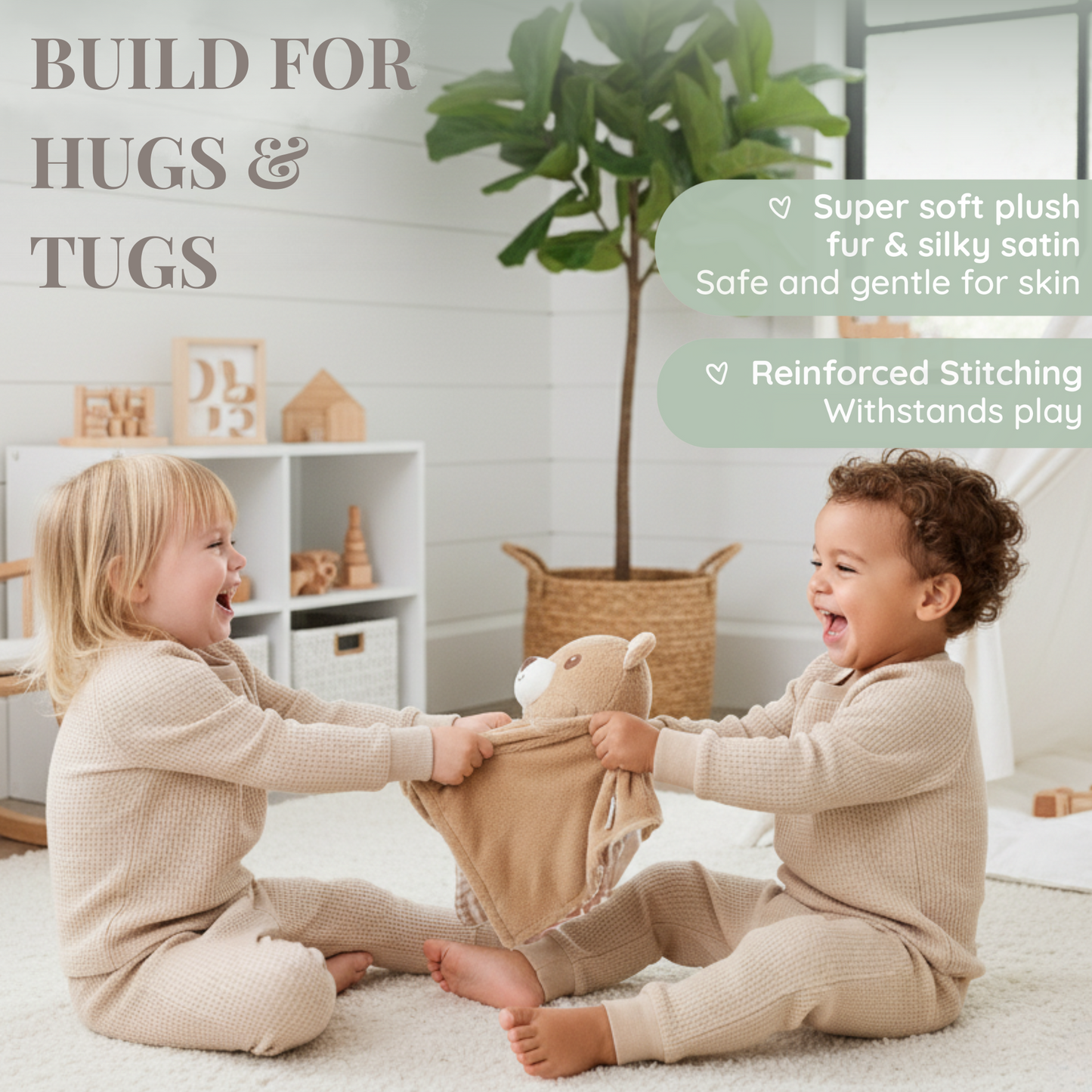 Two laughing toddlers in matching pyjamas play tug-of-war with a Zelkii teddy bear LuviDuvi lovey, demonstrating its 'Reinforced Stitching